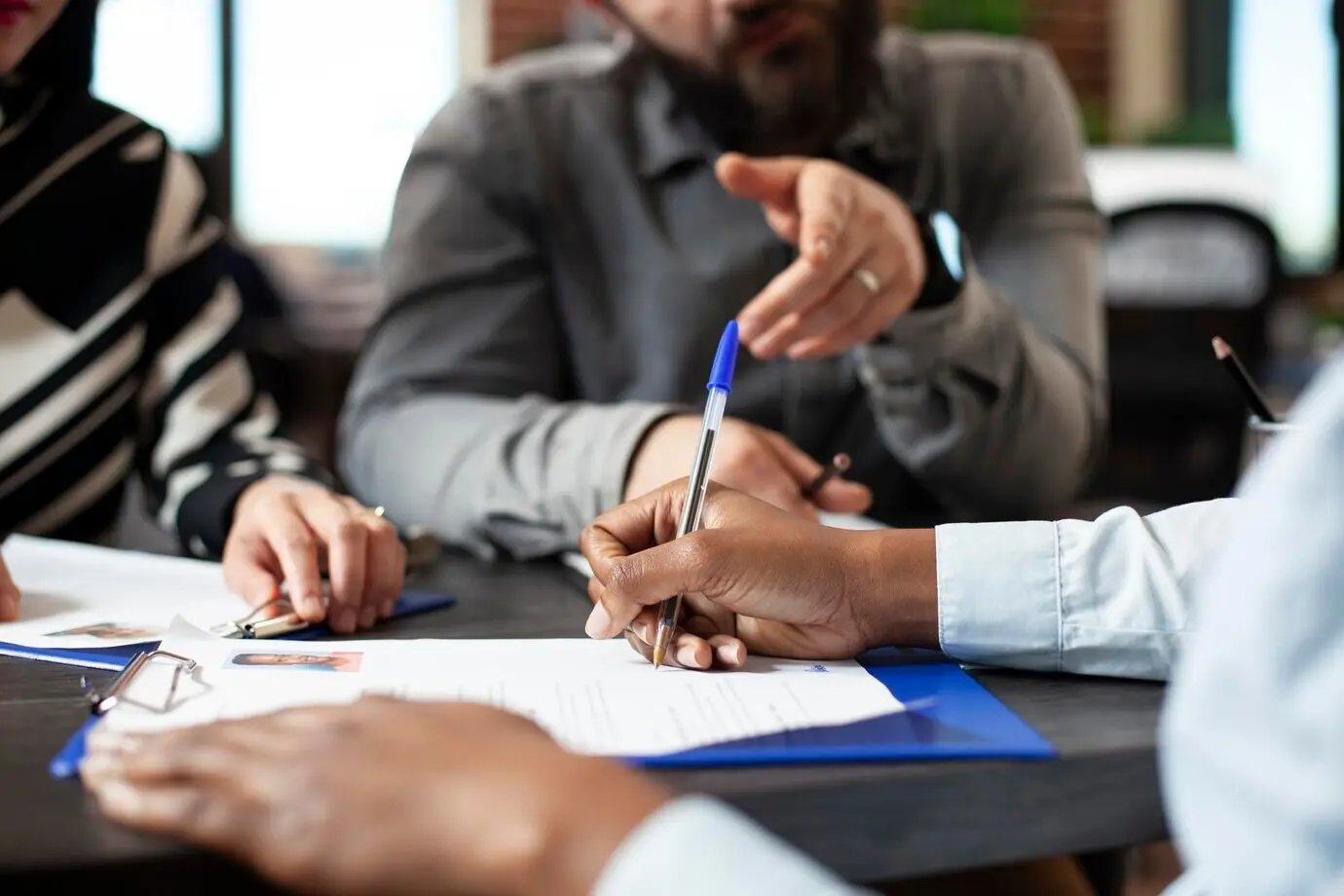 Чернокожий человек подписывает трудовой договор.